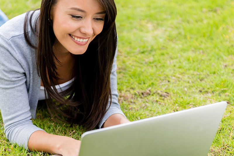 Student using laptop on grass