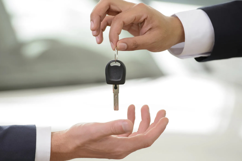 Person giving car keys to someone