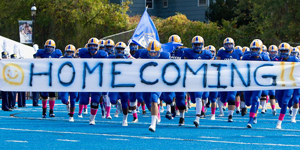 Football players holding Homecoming banner