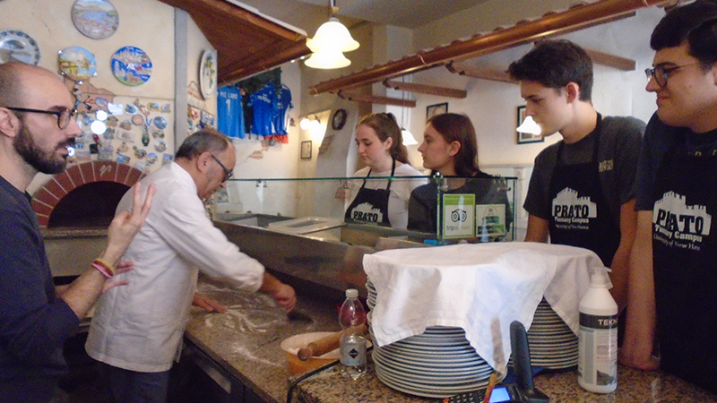 Gerardo Tortora (in white) demonstrates how to make a pizza.