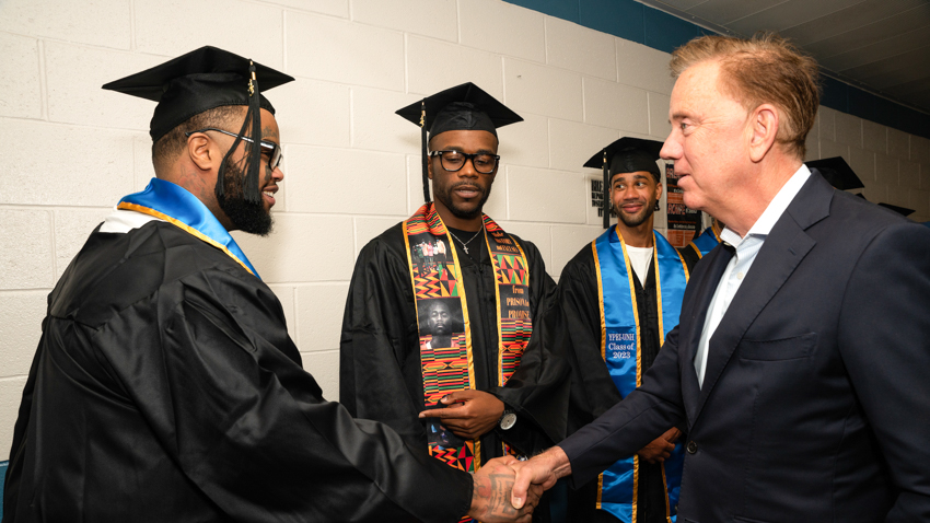 2023 graduates at the MacDougall-Walker Correctional Institution shake hands with Governor Ned Lamont