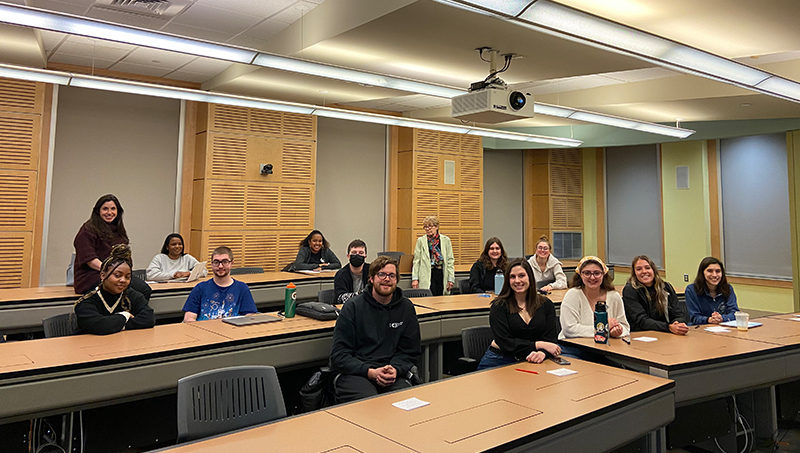Students pose at their desks in a classroom.