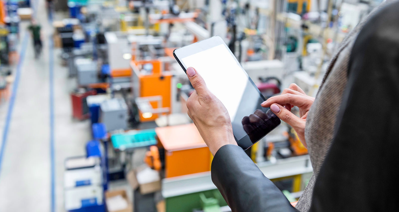 Hands holding tablet in warehouse