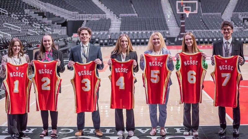 Students holding basketball jerseys
