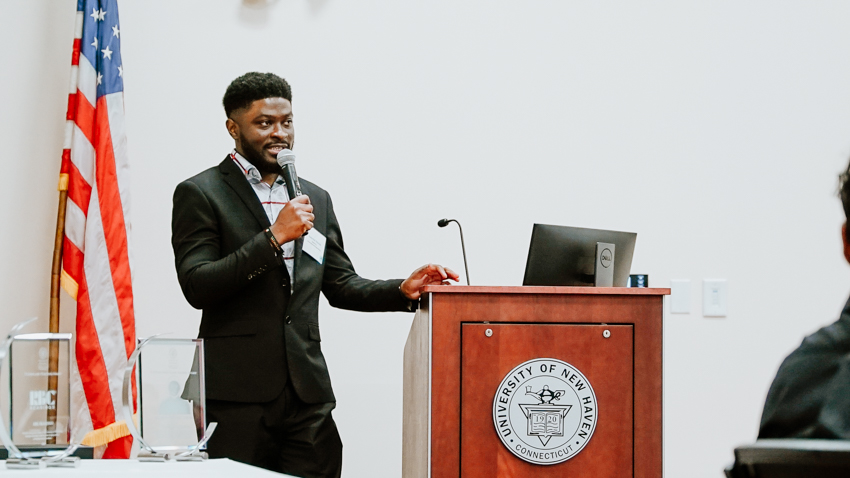 Kadmiel B. Adusei '20 M.S. speaking at a podium