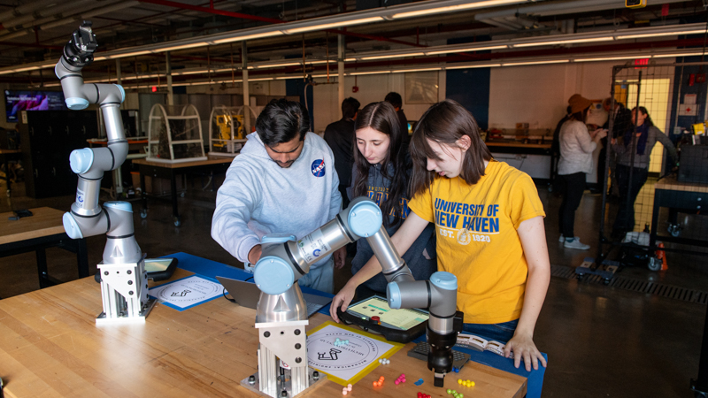 Students working on a robotoic arm.