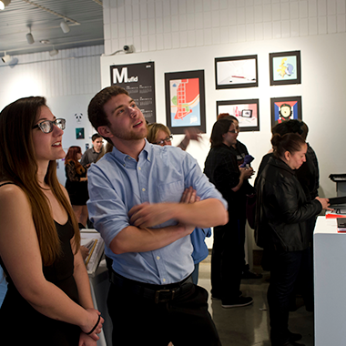 People looking at an art exhibition in the Seton Gallery.