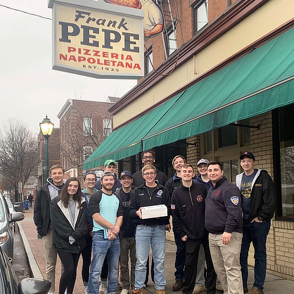 Nolan Heiden ’23 (far left, back) with members of the Fire Science /U+0026 Emergency Management LLC at Frank Pepe Pizzeria Napoletana in New Haven.