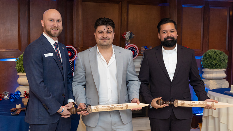 Ryan Noonan /U+0026#x27;20, /U+0026#x27;23 M.S. (left) presented Rudis swords to Anthony Camera ’23 (center) and Erik Clement ’23.