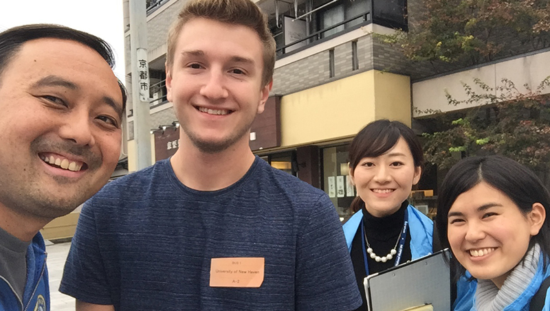 Ryan Dougherty poses with three other people for the camera.