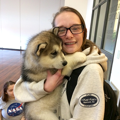 Kaelea Caporuscio /U+0026#x27;20 cuddles a Malamute puppy.