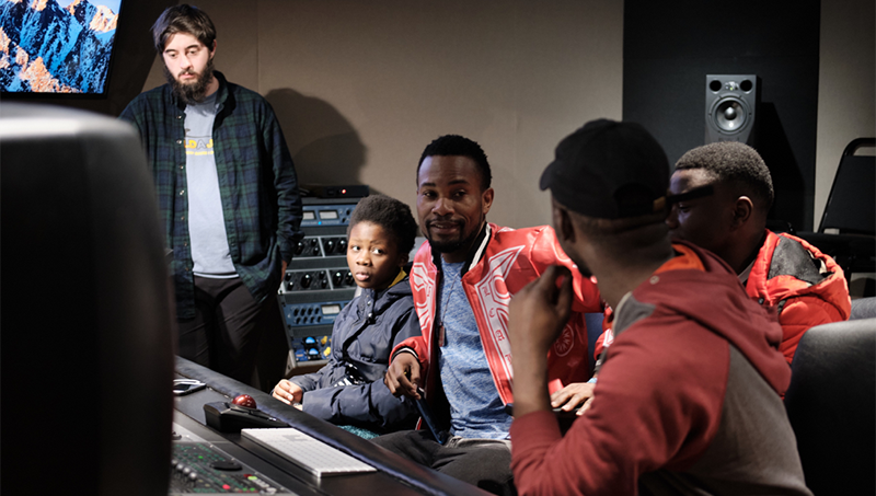Joey Stanca ’20 and Upendo choir members in the University of New Haven recording studio.