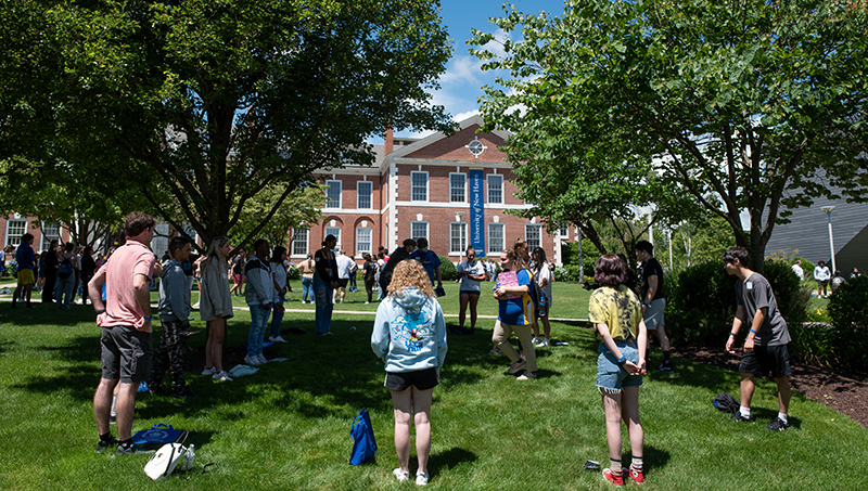 Students and orientation leaders play a game on the lawn.