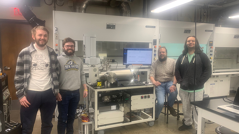 Left to right: Sean Allen /U+0026#x27;23, /U+0026#x27;24 M.S., James McEwan ’24, Dr. Nathan Seifert, and Dominick Panzino ’23, ’24 M.S. with the microwave spectrometer.